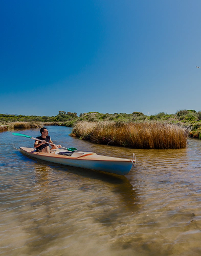 Giovane in canoa durante le escursioni nella laguna di Nora, tra canali limpidi e vegetazione palustre del parco lagunare Nora, immerso nell’ecosistema lagunare.