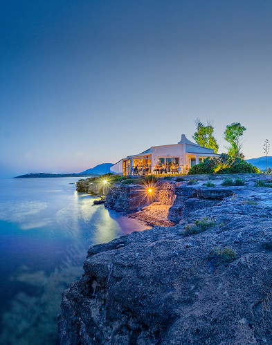 Il ristorante Fradis Minoris al tramonto, affacciato sul mare all’interno del parco lagunare Nora. Immerso nella Laguna di Nora, offre cucina sostenibile in un contesto unico, ideale dopo le visite guidate dedicate all’ecosistema lagunare.
